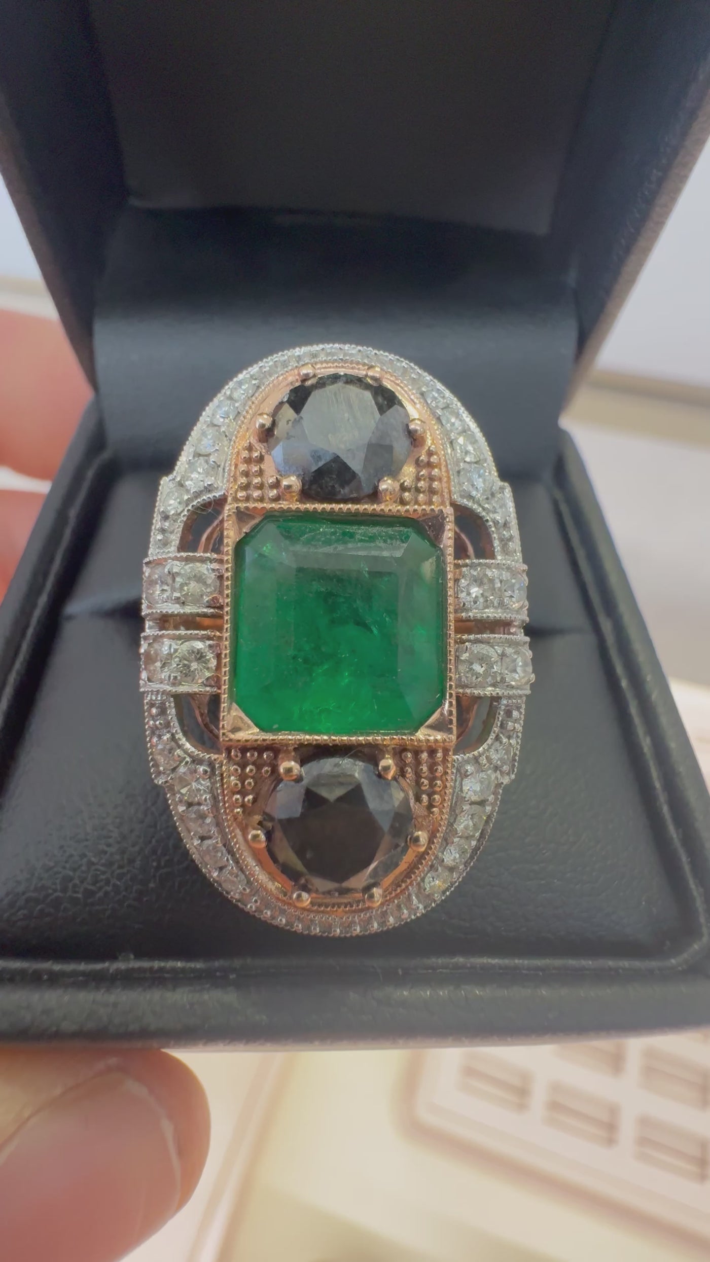 EMERALD, DIAMOND AND BLACK DIAMOND RING